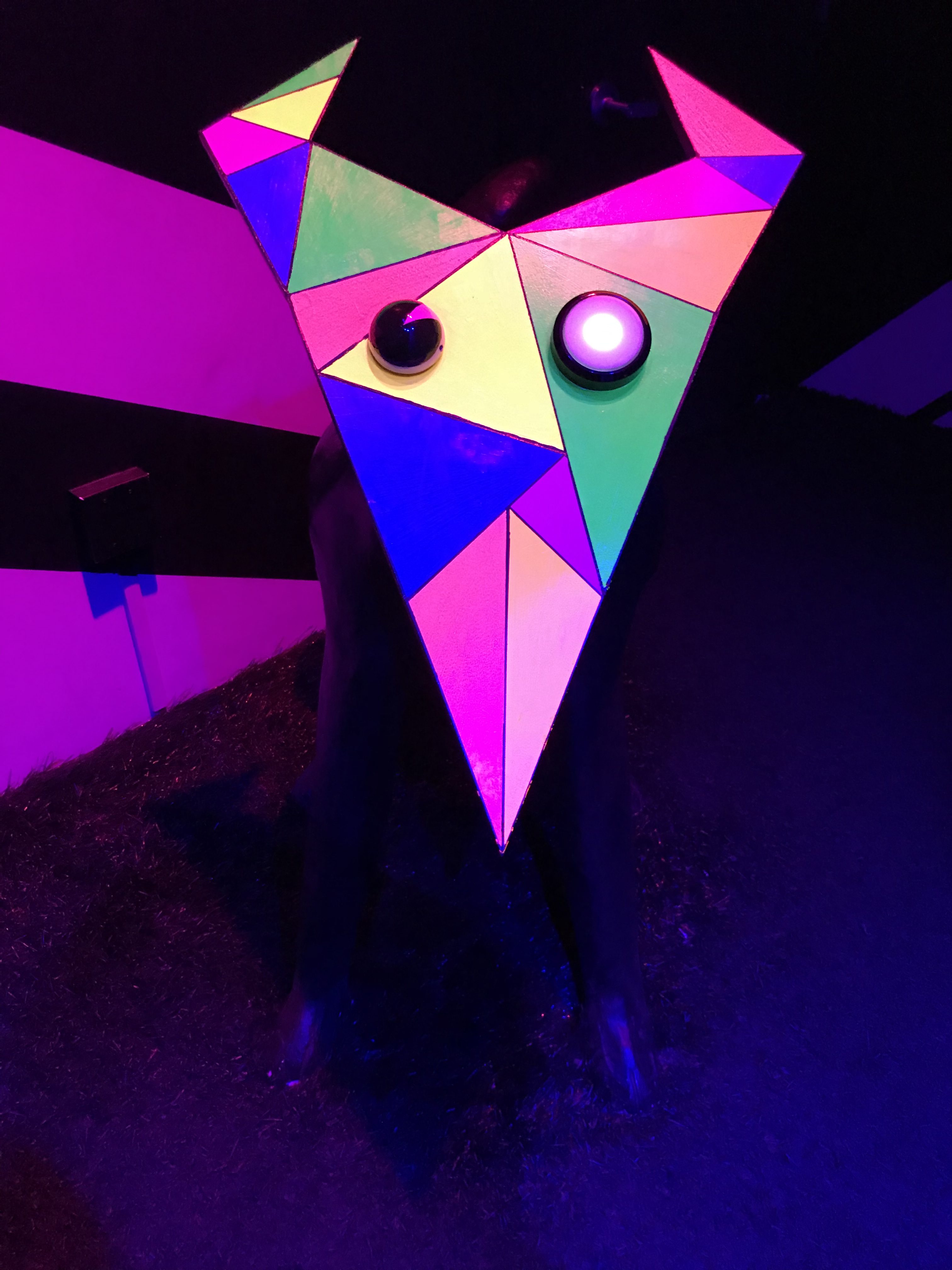 sculpture from Meow Wolf - doglike creature with triangular face and prismatic rainbow coloration